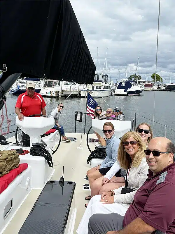 A team seated together on a sailboat on the water during a Full Sail Leadership workshop