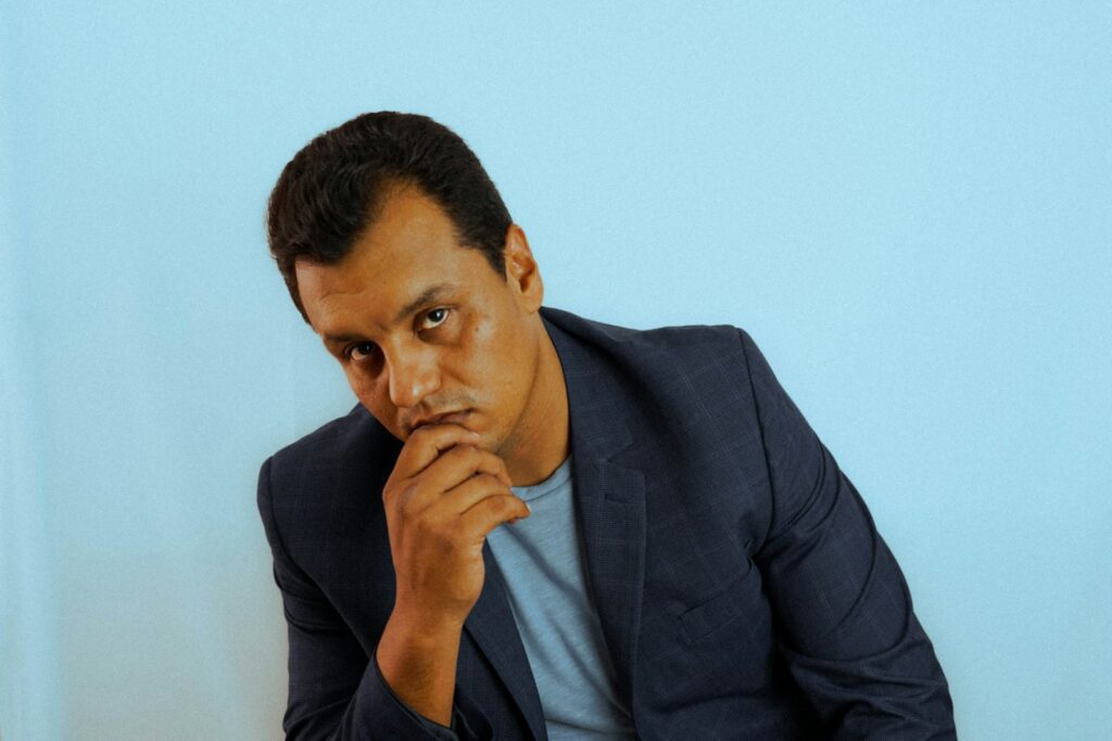 A leader pauses in thought at his desk, hand resting on his chin